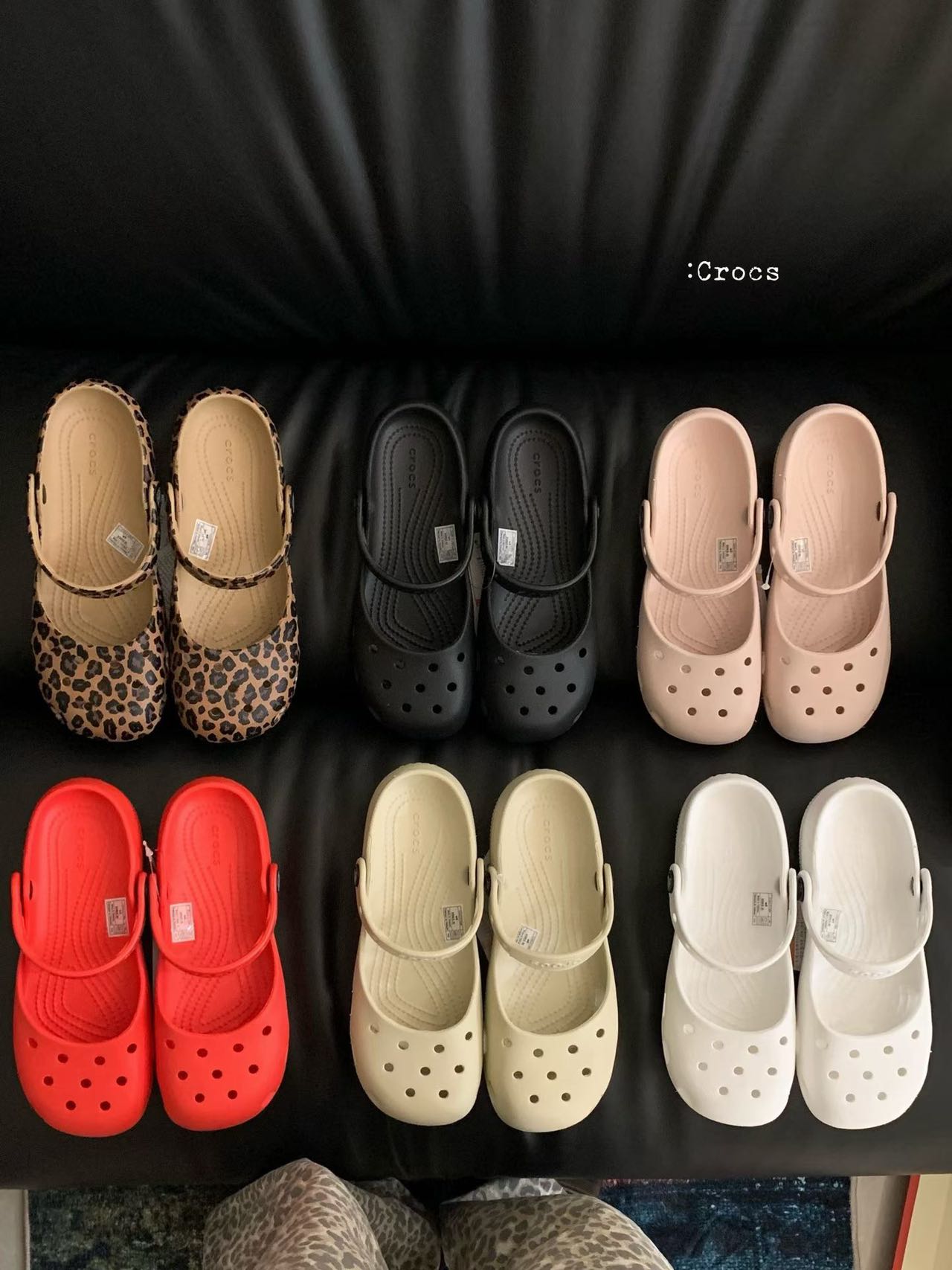 Multiple clog shoe colors arranged on black surface